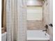 Compact bathroom with a shower-tub combo and patterned curtain providing a touch of design at 4320 Auston Way, Palm Harbor, FL 34685