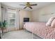 Cozy bedroom with plush carpet, soft pink bedding, ceiling fan, and natural light at 4320 Auston Way, Palm Harbor, FL 34685