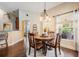 Charming dining area with a round wooden table, chandelier, and a view of the outdoor space at 4320 Auston Way, Palm Harbor, FL 34685