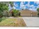 Charming single story home featuring a well-manicured lawn, landscaping, and a three car garage at 4320 Auston Way, Palm Harbor, FL 34685