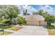 Beautiful home featuring an attached three car garage, lush tropical landscaping and a well kept lawn at 4320 Auston Way, Palm Harbor, FL 34685