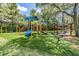 Vibrant playground area with swings and slides set against lush greenery, offering a safe and fun-filled outdoor space for children at 4320 Auston Way, Palm Harbor, FL 34685