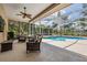 Screened in lanai with comfortable seating overlooking a private pool and lush landscaping at 4320 Auston Way, Palm Harbor, FL 34685