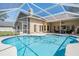 Backyard pool with enclosure, outdoor seating, and a view of the home's exterior at 4320 Auston Way, Palm Harbor, FL 34685