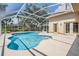 Outdoor pool with screened enclosure and landscaped backyard with lush vegetation at 4320 Auston Way, Palm Harbor, FL 34685