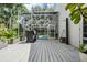 Backyard deck with shower, outdoor grill, screened pool enclosure and surrounding trees at 4797 Stonebriar Dr, Oldsmar, FL 34677