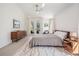 Bright bedroom features a ceiling fan, a large rug, and doors leading to the outdoors at 4797 Stonebriar Dr, Oldsmar, FL 34677