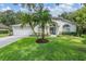 Charming home featuring a well-manicured lawn, arched windows, and a blue front door at 4797 Stonebriar Dr, Oldsmar, FL 34677