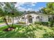 Charming home featuring a well-manicured lawn, arched windows, and a blue front door at 4797 Stonebriar Dr, Oldsmar, FL 34677