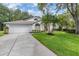 Charming home featuring a well-manicured lawn, arched windows, and a blue front door at 4797 Stonebriar Dr, Oldsmar, FL 34677