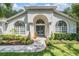 Elegant home featuring an arched entryway, meticulously landscaped garden beds, and a pristine walkway at 4797 Stonebriar Dr, Oldsmar, FL 34677