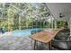 Relaxing screened-in pool with dining area, chairs, and trees offering shade in the backyard at 4797 Stonebriar Dr, Oldsmar, FL 34677