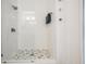 Walk-in shower featuring a mosaic tile floor, white tile walls, and modern fixtures at 4797 Stonebriar Dr, Oldsmar, FL 34677