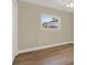 A cozy bedroom featuring wood-look floors, white trim, and a sunny window at 5008 Stolls Ave, Tampa, FL 33615