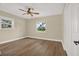 This bedroom features wood-look floors, a ceiling fan with light, and bright windows at 5008 Stolls Ave, Tampa, FL 33615