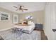 Cozy bedroom with a queen-size bed, decorative rug, ceiling fan, and sunny windows at 5008 Stolls Ave, Tampa, FL 33615