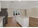 Bright, open kitchen featuring a large island, stainless steel refrigerator, and sliding doors to outdoor patio at 5008 Stolls Ave, Tampa, FL 33615