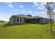 Green backyard featuring the home's exterior with multiple windows and doors and a well-maintained lawn at 5116 Wildwind Dr, Apollo Beach, FL 33572