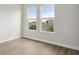 Serene bedroom with light wood floors and two windows offering neighborhood views at 5116 Wildwind Dr, Apollo Beach, FL 33572