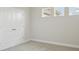 Bright bedroom with double doors, neutral carpet, and two small windows at 5116 Wildwind Dr, Apollo Beach, FL 33572