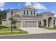 Beautiful two-story home boasting a three-car garage, manicured lawn, and landscaped front yard at 5116 Wildwind Dr, Apollo Beach, FL 33572