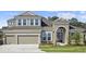 Charming two-story home with a manicured lawn and a two-car garage. It has a modern design and a welcoming entrance at 5116 Wildwind Dr, Apollo Beach, FL 33572