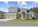 Inviting two-story home with a three-car garage, manicured lawn, and charming front entrance at 5116 Wildwind Dr, Apollo Beach, FL 33572
