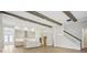 Spacious living room leading into kitchen, featuring wooden beams and stairs, creating an airy and open space at 5116 Wildwind Dr, Apollo Beach, FL 33572