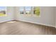 Spacious living room featuring light wood flooring and an abundance of natural light from large windows at 5116 Wildwind Dr, Apollo Beach, FL 33572