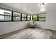 Bright living room featuring plank flooring, white-painted wood paneled walls, and large windows at 535 31St N Ave, St Petersburg, FL 33703