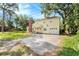 Back yard view of a two-story home featuring a spacious yard, patio, and mature trees at 6024 90Th N Ave, Pinellas Park, FL 33782