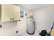 Utility room featuring a water heater, cabinets, and a window at 6024 90Th N Ave, Pinellas Park, FL 33782