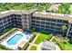 Aerial view of the condo building with pool, courtyard, and manicured greenery at 6100 Gulfport S Blvd # 114, Gulfport, FL 33707
