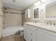 Well-lit bathroom with a double sink vanity, tiled shower, and tub combination at 6100 Gulfport S Blvd # 114, Gulfport, FL 33707