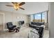 Bright living room featuring plush seating, a ceiling fan, and a large window with pleasant neighborhood views at 6322 Palma Del Mar Blvd S # 604, St Petersburg, FL 33715