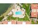 Aerial view of the community pool and sunbathing deck with lounge chairs and tiki umbrellas at 6322 Palma Del Mar Blvd S # 604, St Petersburg, FL 33715