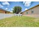 Spacious backyard with manicured lawn, mature trees, and Adirondack chairs around a fire pit at 6519 Twin Bridges Dr, Zephyrhills, FL 33541