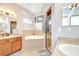 Bright bathroom featuring double vanities, a soaking tub with tile surround and a separate shower with a glass door at 6519 Twin Bridges Dr, Zephyrhills, FL 33541