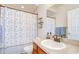 Bathroom featuring a vanity with mirror and sink, toilet, shelving and shower with a decorative curtain at 6519 Twin Bridges Dr, Zephyrhills, FL 33541