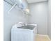 A functional laundry room with modern, white appliances and wire shelving for storage at 6519 Twin Bridges Dr, Zephyrhills, FL 33541
