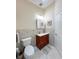 Cozy bathroom featuring a cherry vanity with a white sink, a decorative mirror and neutral tile backsplash at 659 Garland Cir, Indian Rocks Beach, FL 33785