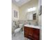 Cozy bathroom featuring a cherry vanity with a white sink, a decorative mirror and neutral tile backsplash at 659 Garland Cir, Indian Rocks Beach, FL 33785