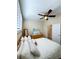 Comfortable bedroom featuring a ceiling fan, shuttered windows and a view into an ensuite bathroom at 659 Garland Cir, Indian Rocks Beach, FL 33785