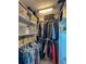 Walk in closet with custom white shelves, drawers, and hanging racks for optimal organization and storage at 659 Garland Cir, Indian Rocks Beach, FL 33785