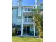 Charming condo with dual balconies, a patio with green Adirondack chairs, and tropical landscaping at 659 Garland Cir, Indian Rocks Beach, FL 33785