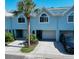 Charming townhome with a private garage, a lush palm tree and mature landscaping at 659 Garland Cir, Indian Rocks Beach, FL 33785