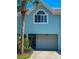 Two-story condo featuring an attached garage and well-maintained landscaping in front at 659 Garland Cir, Indian Rocks Beach, FL 33785