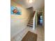 Inviting hallway featuring tiled floors, staircase, and a coastal-themed turtle artwork at 659 Garland Cir, Indian Rocks Beach, FL 33785