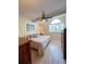 Bright main bedroom with a ceiling fan, a large window with blinds, and light-colored wood flooring at 659 Garland Cir, Indian Rocks Beach, FL 33785