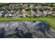Aerial view of a backyard overlooking a tranquil pond, providing a serene and private setting at 816 College Chase Dr, Ruskin, FL 33570